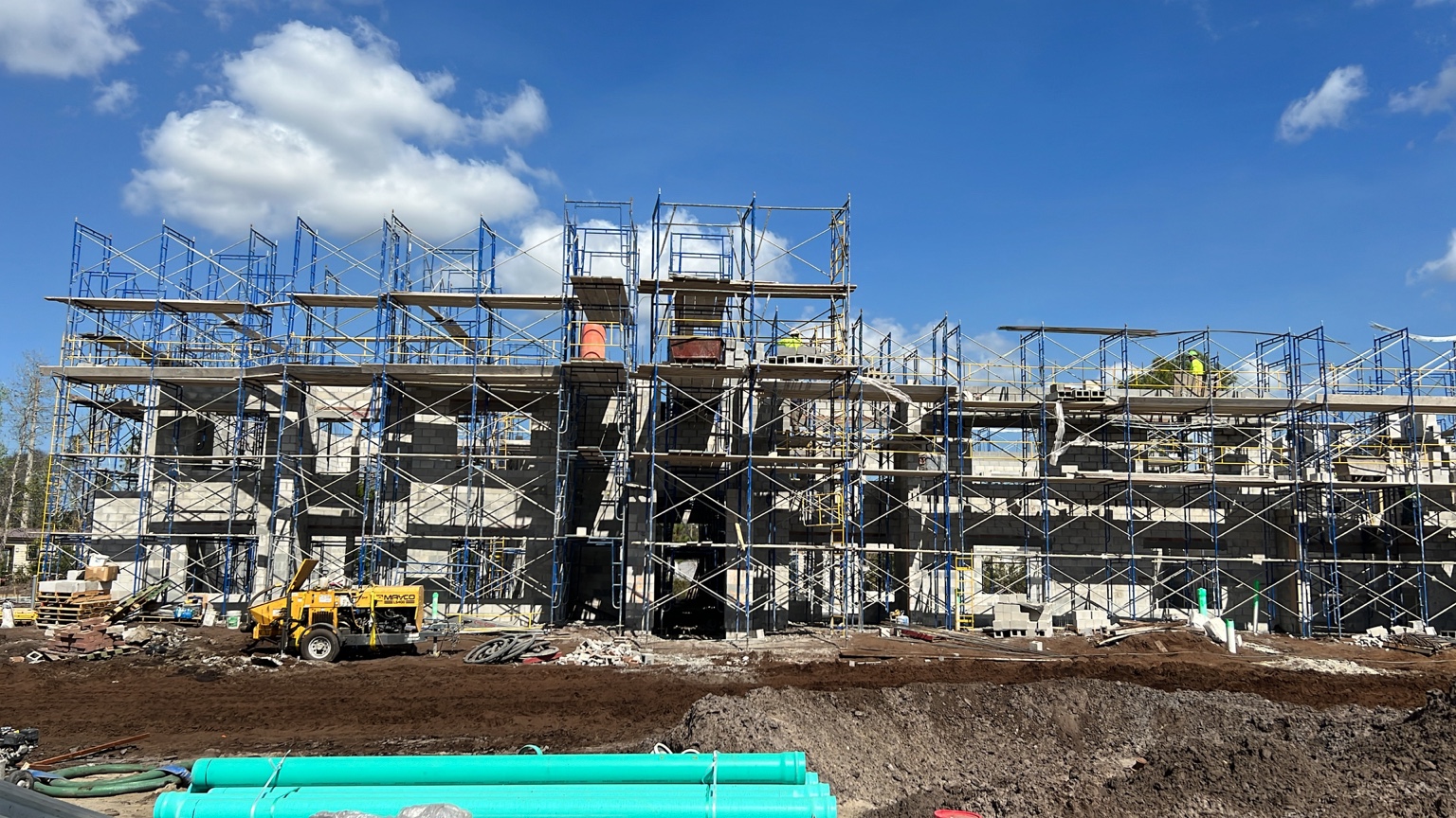 Commercial CMU building under construction with scaffolding